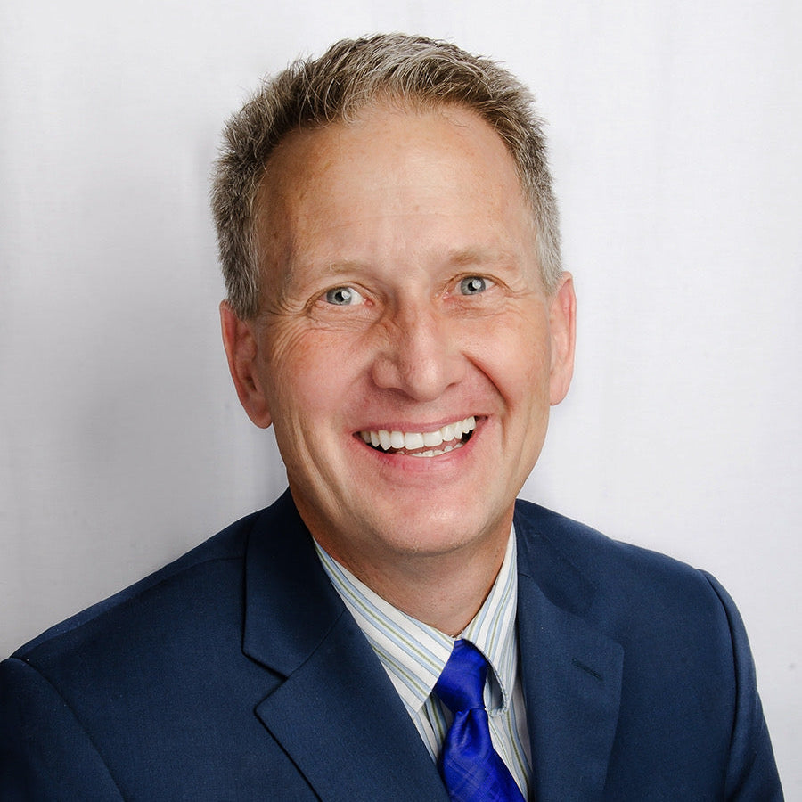 Man wearing a blue suit and tie against a white background