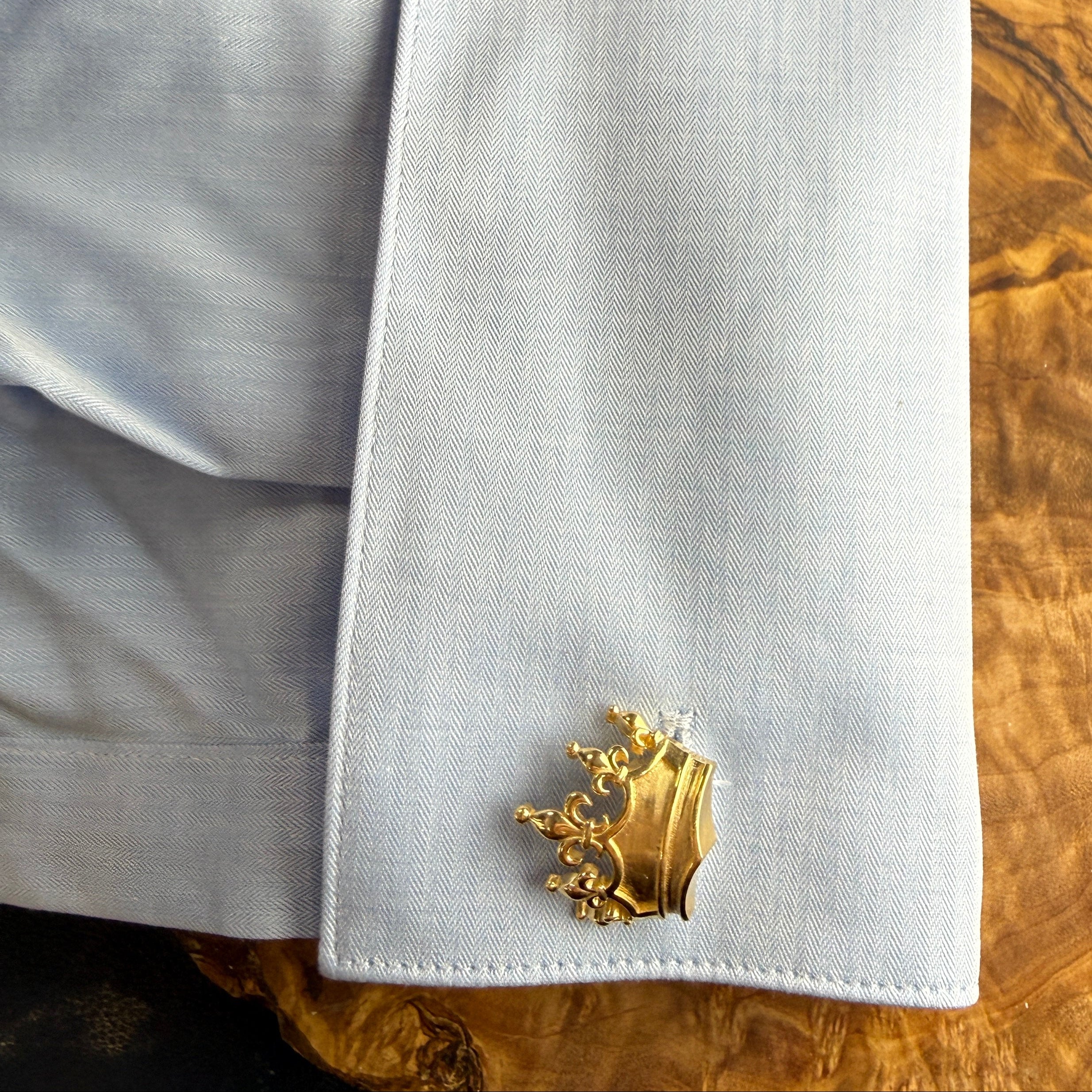 White pocket square with a gold emblem on a wooden surface
